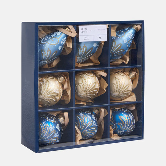 Set of blue and gold Christmas ornaments in a navy box with a visible brand label.