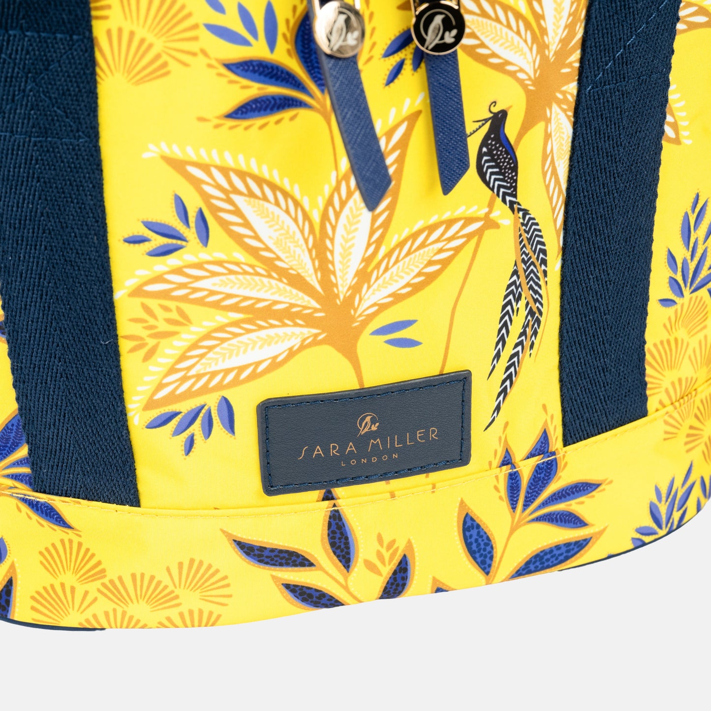 Yellow bag with blue floral pattern and 'Sara Miller London' branding.