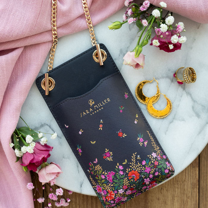 Phone pouch flat lay on table with flower props.