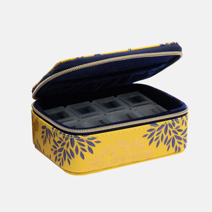 Open wellness organiser showing inside indigo velvet lining and plastic pill organiser.