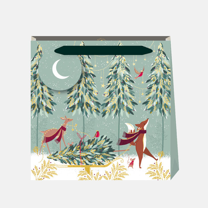 Gift bag with forest design featuring deer and trees on a light blue background