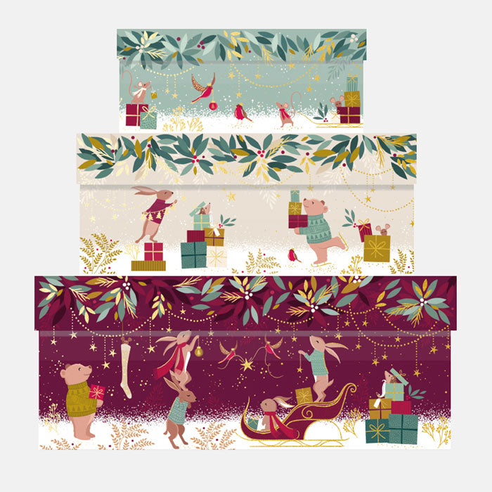Three decorative cardboard boxes with festive illustrations on a white background