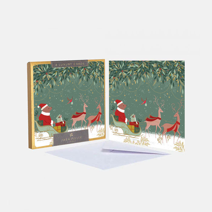 Set of Christmas-themed greeting cards with Santa and reindeer design, featuring a box of cards on a white background.