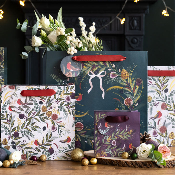 A collection of gift bags all with fig & fern festive designs, in shades of green, red and cream. A playful twist on traditional Christmas gift wrapping.