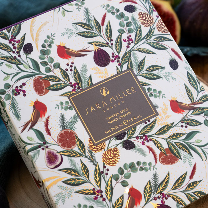 A close-up of a Sara Miller London Winter Spice Hand Cream box, decorated with an intricate festive botanical and bird pattern on a white background.