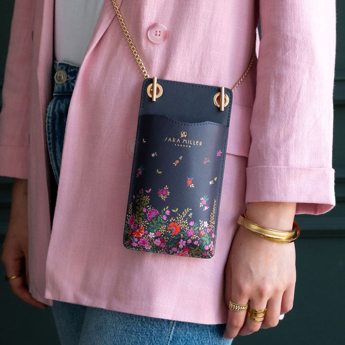 Model wearing ditsy floral phone pouch, can see scale and gold chain detail.