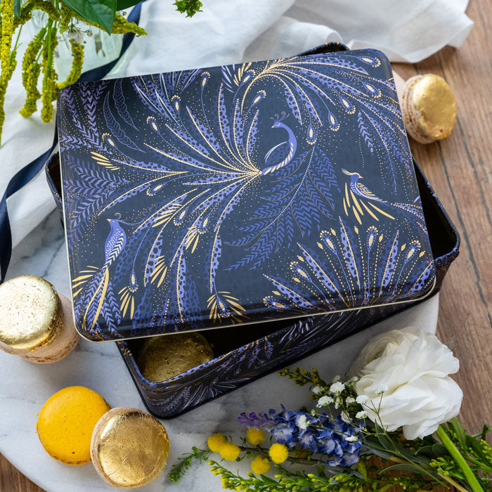 Rectangular tin featuring peacock parade design with swooping tail feathers, in velvety indigo.