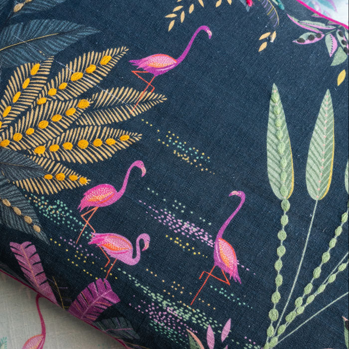 Close-up of fabric with tropical leaf and flamingo pattern on a navy background, linen texture.