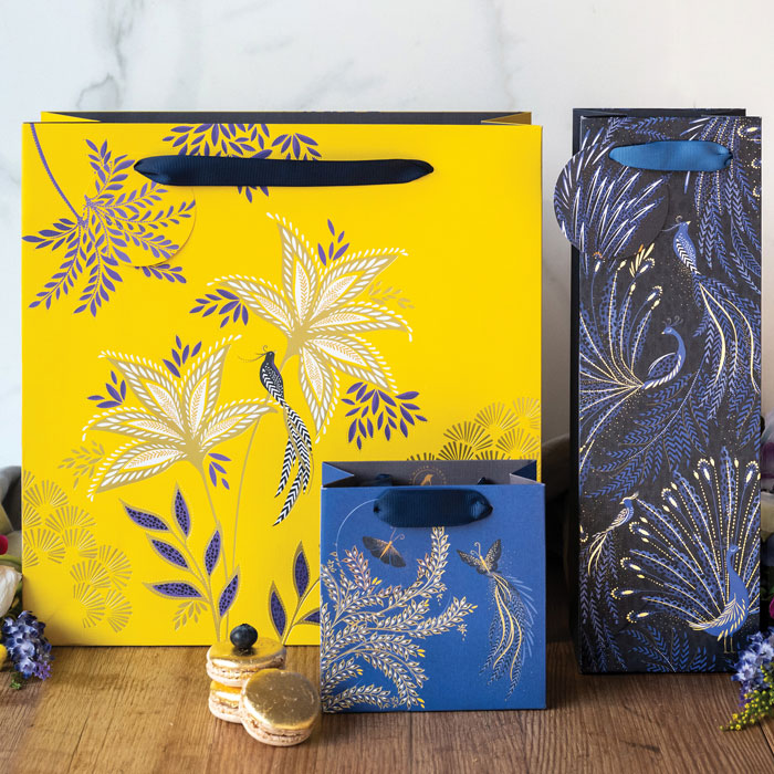 Three anniversary collection gift bags in different colours and designs, including yellow gift bag.