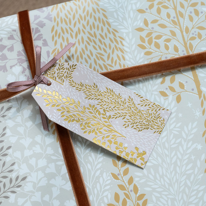 Gift tag with gold leaf pattern and ribbon.