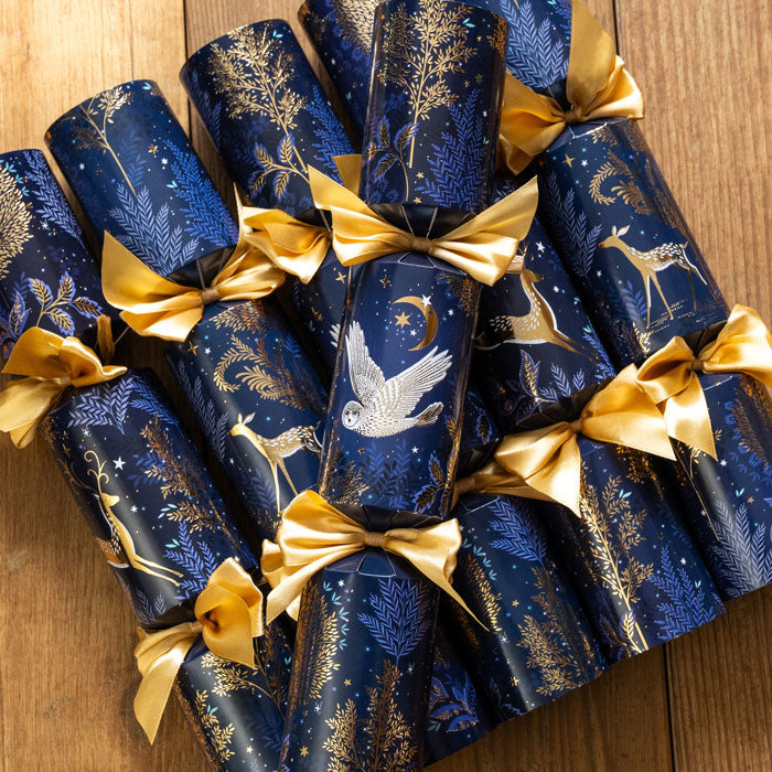 Decorative blue crackers with gold ribbons on a wooden surface