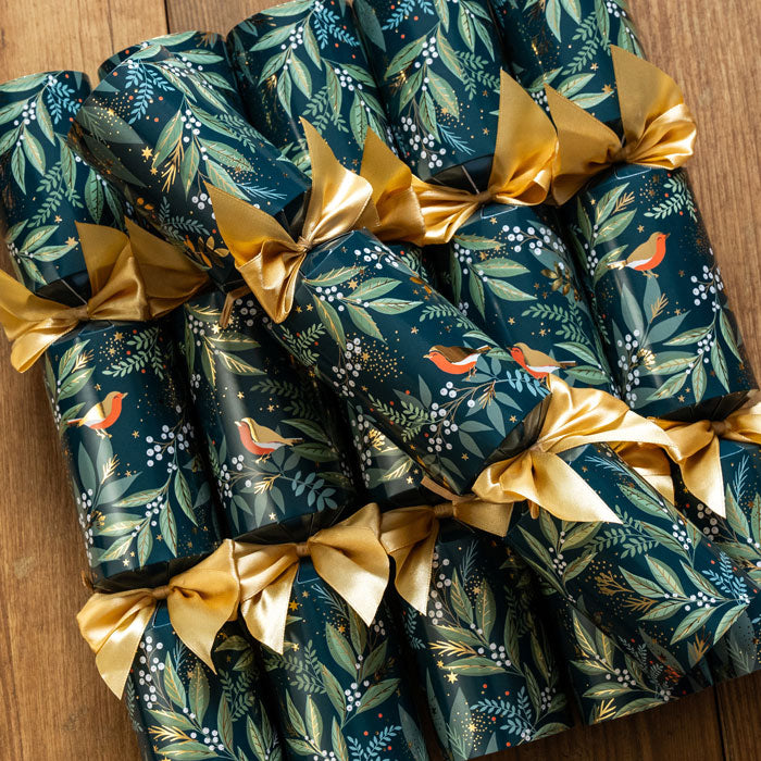 Decorative Christmas crackers with gold ribbons on a wooden surface