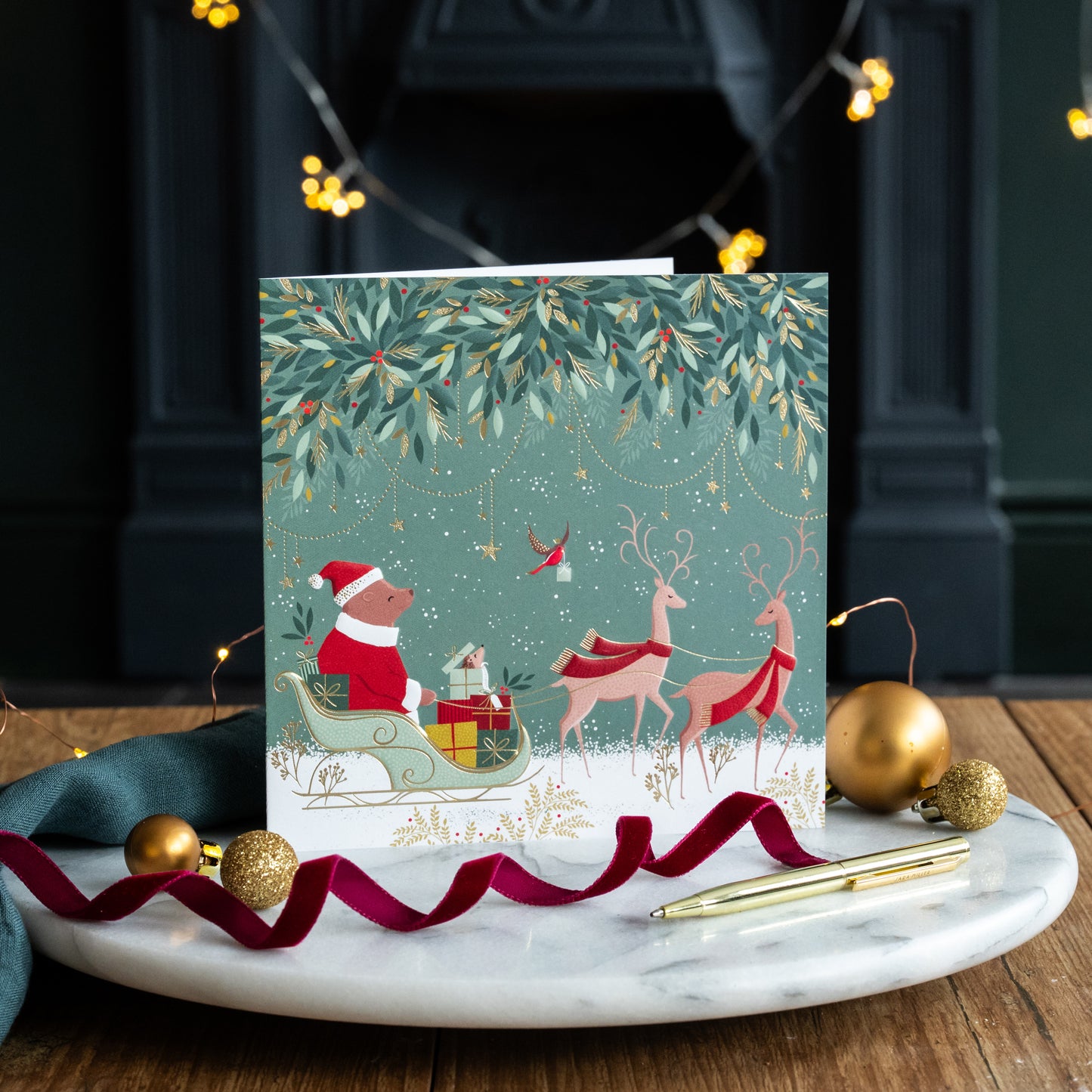 Christmas card with Santa and reindeer design on a marble tray with festive decorations.