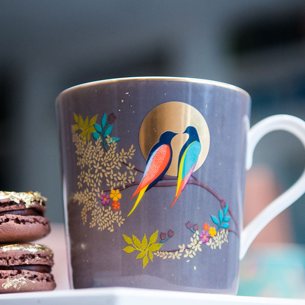 Grey china mug with birds in moonlight design. Birds sitting on branch in front of moon.