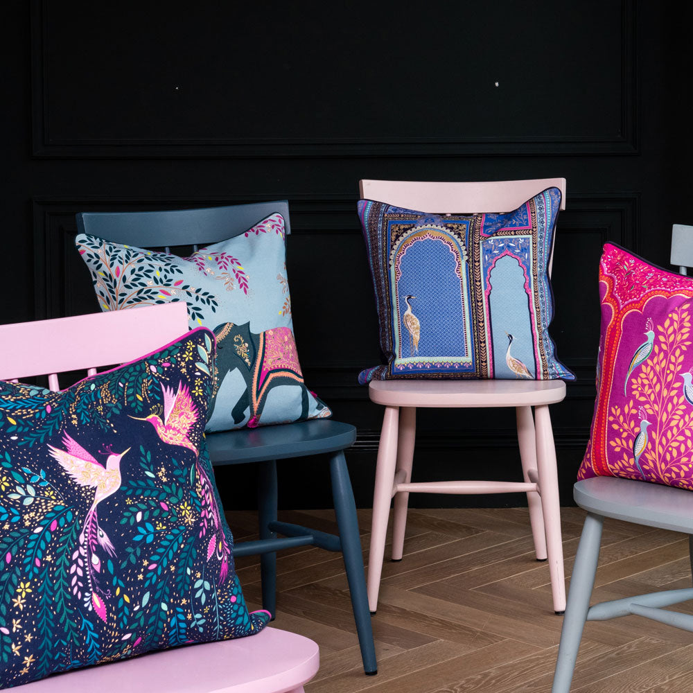 Four chairs with cushions on top all from our India collection, in shades of blue and pink with intricate designs.
