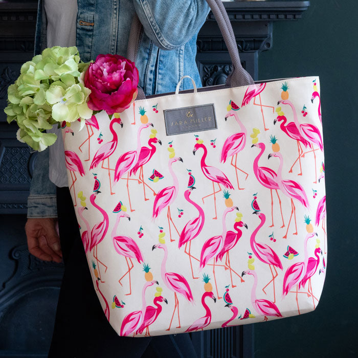 Flamingo print tote bag in shades of pink, on cream background with grey handles and interior.