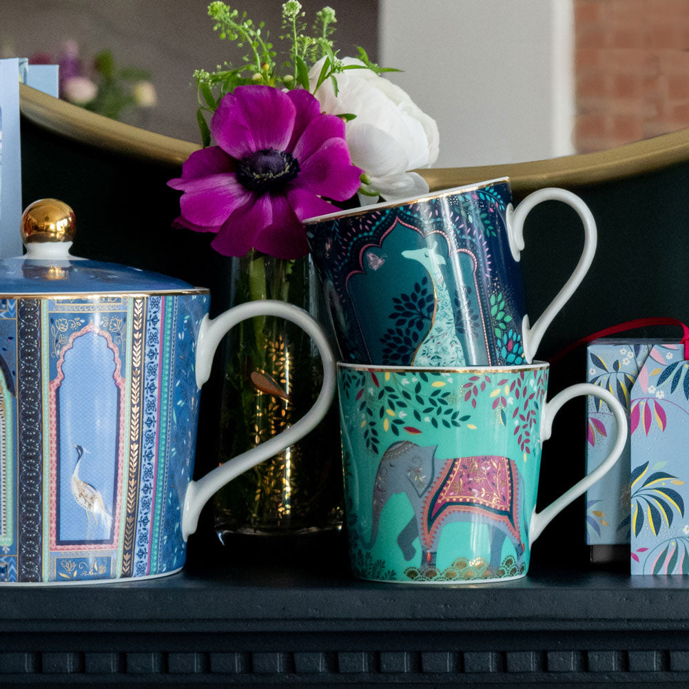 Two mugs from the same collection and matching tea pot all together.