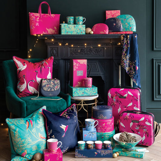 A collection of products stacked in front of a fireplace with festive accents. 