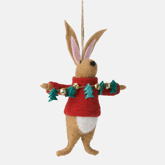 Felted rabbit ornament wearing a red sweater with Christmas decorations on a white background