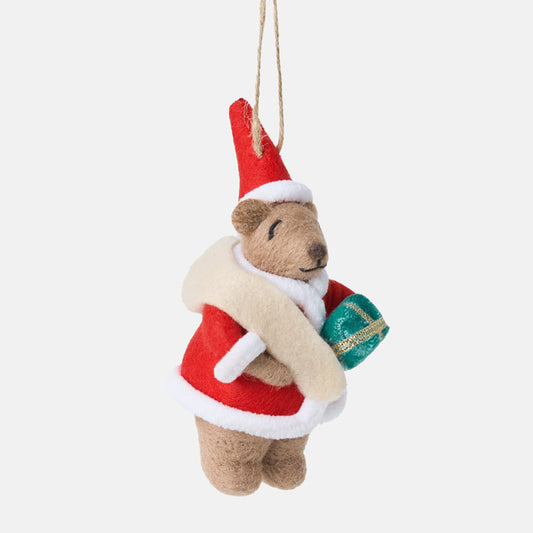 Felted bear ornament dressed as Santa Claus holding a gift on a white background