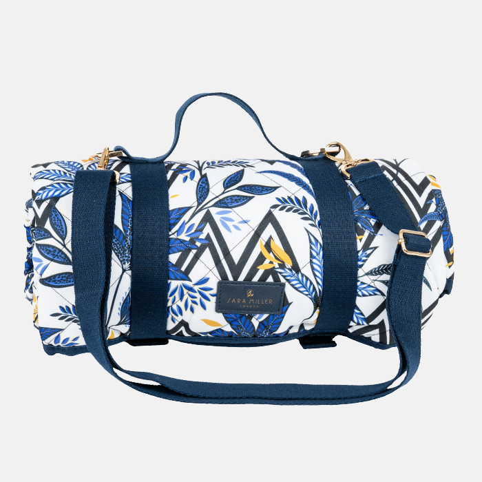 Picnic blanket rolled up with blue and white pattern with carry handles/straps