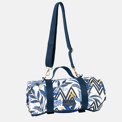 Picnic blanket rolled up with blue and white pattern with carry handles/straps