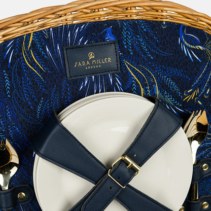 Close-up of a handbag with a 'Sara Miller London brand label on a blue patterned background