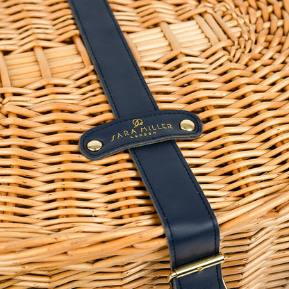 Wicker basket with a navy strap featuring 'Sara Miller London' branding.