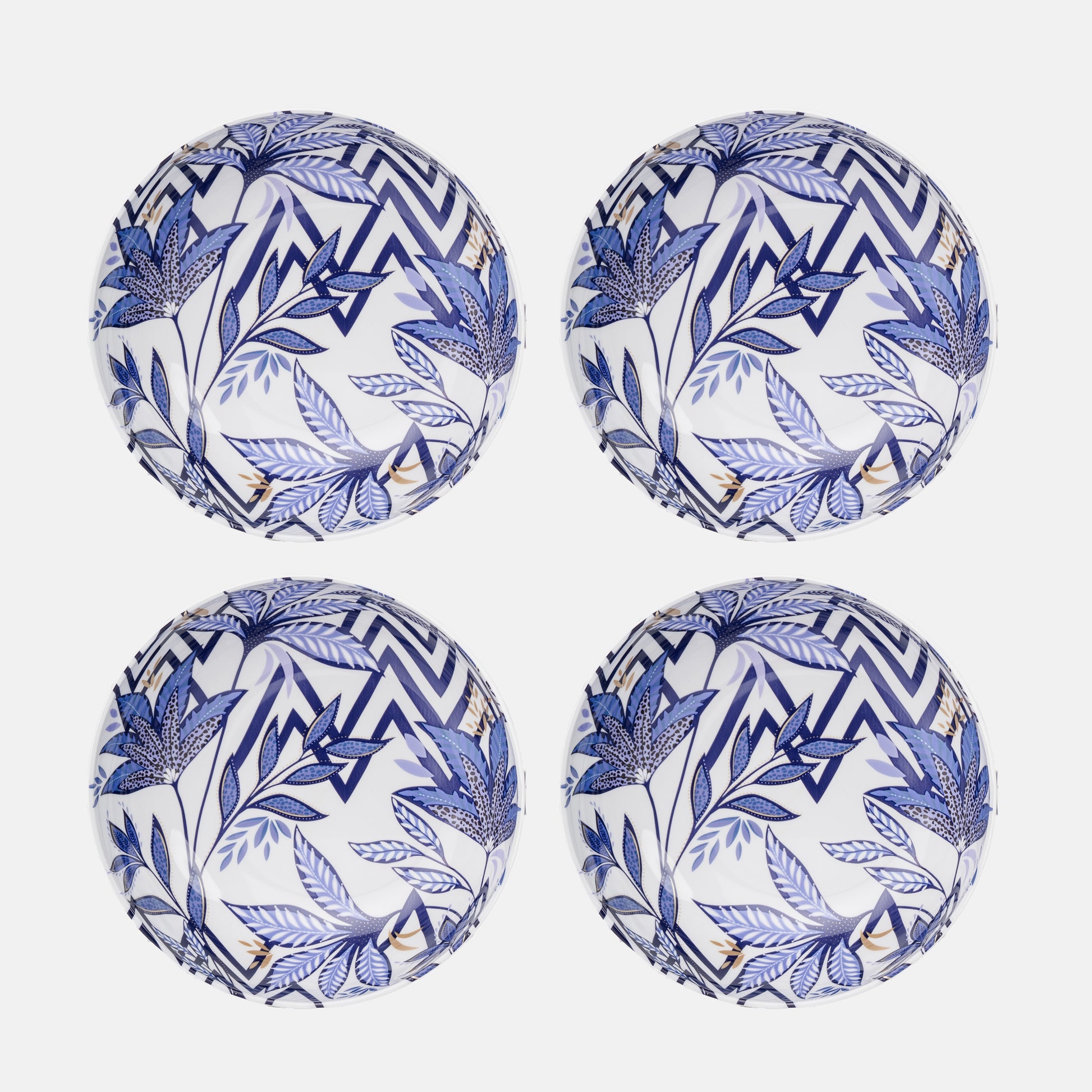 Four blue and white patterned plastic plates on a white background