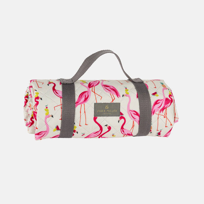 Roll-up picnic blanket with flamingo pattern and grey strap on a white background