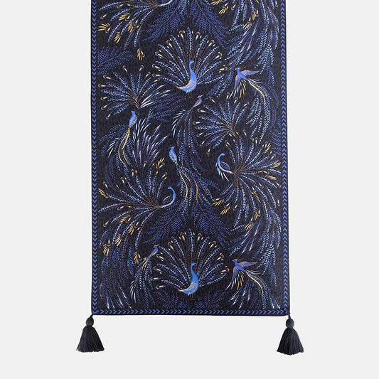 Decorative table runner with peacock design and tassels on a white background