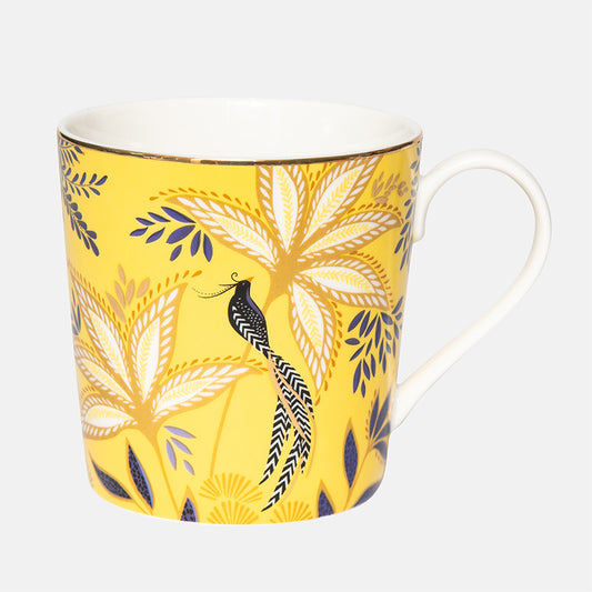 Yellow mug with leaf and bird pattern on a white background