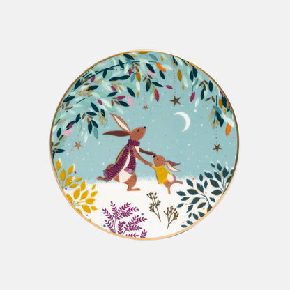 A round decorative coaster featuring an illustrated scene of two rabbits holding hands under a crescent moon, surrounded by autumn leaves and stars on a light green background.