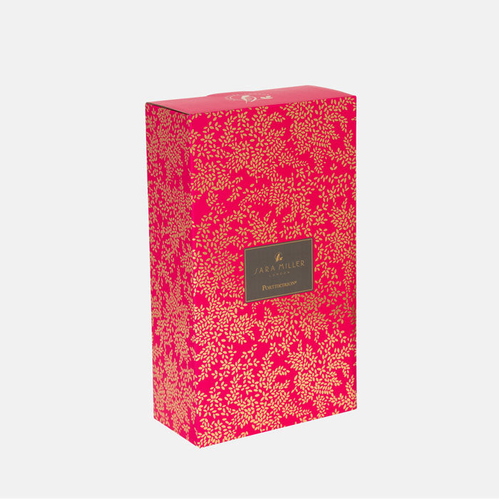 Pink floral-patterned box with a brand label on a white background