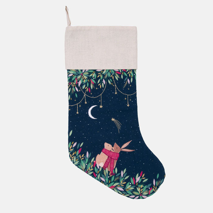 Christmas stocking with a rabbit in moonlit sky design on a dark blue starry background