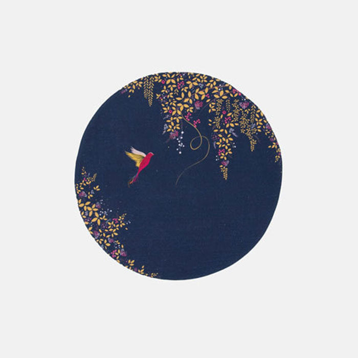 A round navy blue fabric placemat with a hummingbird and foliage design.
