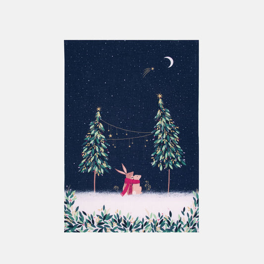 Festive tea towel with rabbits in moonlight design, and Christmas trees on a starry sky background.
