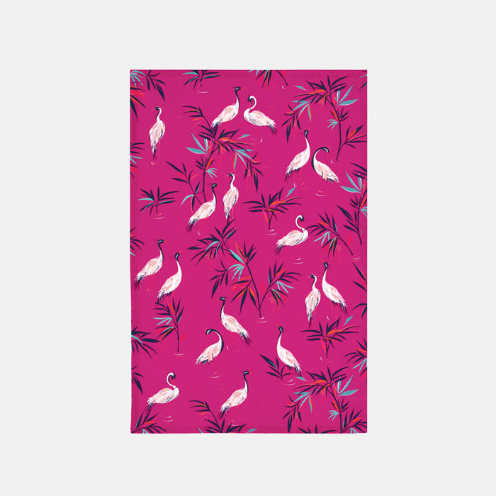 Fabric placemat with white heron birds and bamboo foliage on a bright pink background
