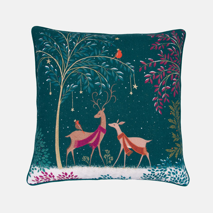 Decorative festive cushion with deer and woodland illustration on a green background
