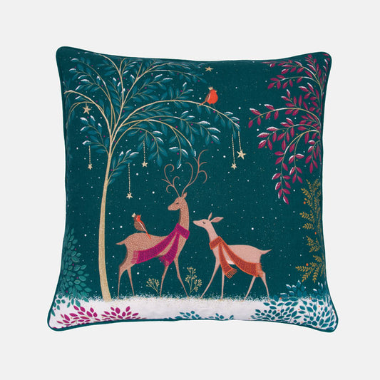 Decorative festive cushion with deer and woodland illustration on a green background
