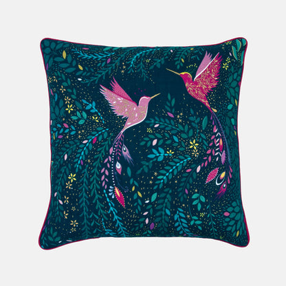 Decorative cushion with pink hummingbirds and green foliage on a dark blue background