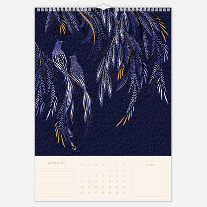 A hanging spiral bound wall calendar with intricate designs, one month per page view.