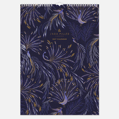 A hanging spiral bound wall calendar with intricate blue peacock design with gold detailing.