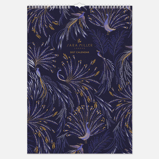 A hanging spiral bound wall calendar with intricate blue peacock design with gold detailing.