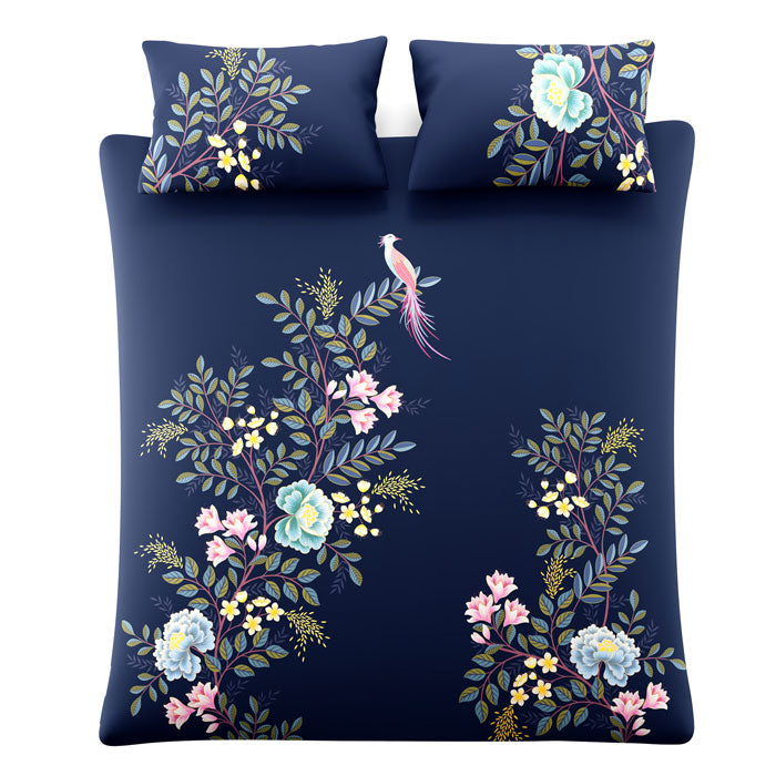Floral and bird design on a navy blue background with matching pillows.