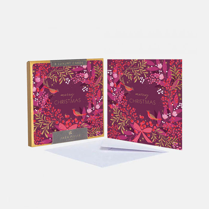 A boxed set of luxury Christmas greeting cards in pink and red colours with festive foliage and birds perched in wreath. 