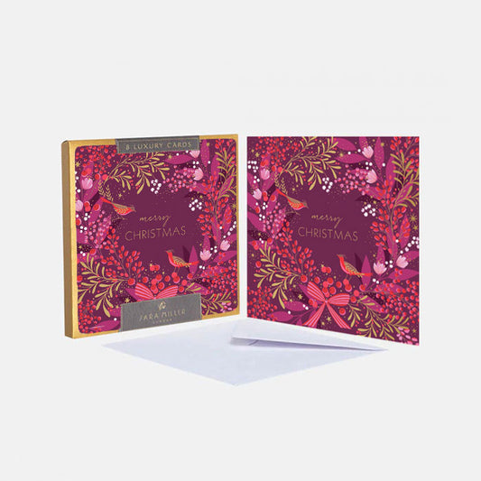 A boxed set of luxury Christmas greeting cards in pink and red colours with festive foliage and birds perched in wreath. 
