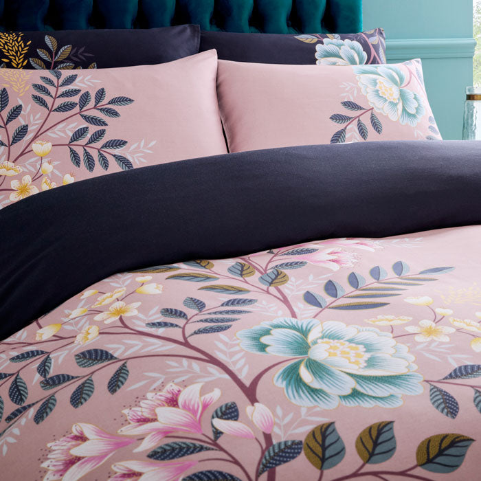 Floral bedding set with pink and navy design on a bed.