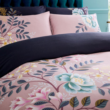Floral bedding set with pink and navy design on a bed.