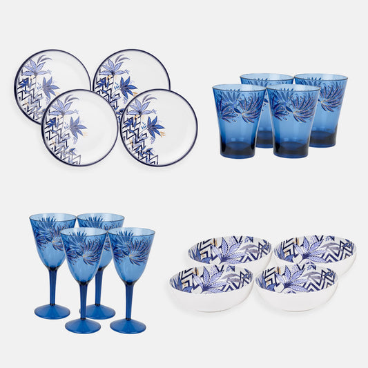Set of four plastic plates, bowls, tumblers and wine glasses against a plain background.
